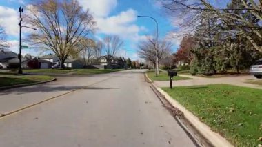 POV, parlak sonbahar ağaçlarıyla dolu cadde boyunca hareket eden arabadan ateş ediyor. Sıcak renkler ve bulutlu gökyüzü mahallelerin güzel bir resmini oluşturur. - Evet. Yüksek kalite 4k görüntü