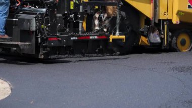 Asfalt asfalt asfalt makinesi yola yeni asfalt döşemiş. Yol silindiri yeni bırakılmış asfalta bastırıyor. Yüksek kalite 4k görüntü
