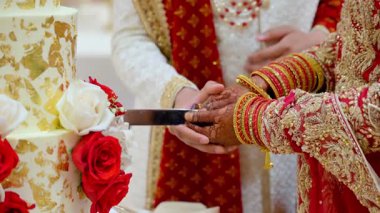 Bir gelin ve bir damat Asyalı düğün partisinde düğün pastası kesiyor. Çekimi kapat. Yüksek kalite 4k görüntü