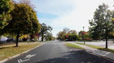 POV dışarıda, banliyö caddesinde ilerleyen parlak sonbahar ağaçlarıyla birlikte arabadan çekiliyor. Sıcak sonbahar renkleri ve parlak mavi gökyüzü mahallelerin güzel bir resmini oluşturur. - Evet. Yüksek kalite 4k görüntü