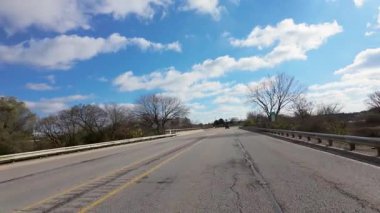 Güzel bir mevsimde trafiğin olduğu karayolu kenarında mavi gökyüzü ve parlak çimlerle değişim zamanı. Yüksek kalite 4k görüntü