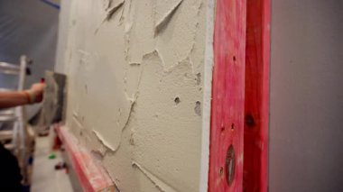 Profesyonel inşaat işçisi seramik fayansı yapıştırmak için duvara yapıştırıcı sürüyor. - Evet. Yüksek kalite 4k görüntü