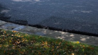 Yol silindiri, savaş halinde, yeni bir yol yüzeyine asfalt bastırıyor. Yüksek kalite 4k görüntü
