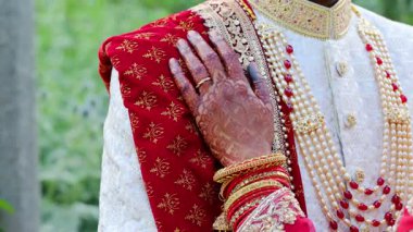 Gelin damada kollarını koydu, geleneksel kırmızı ve beyaz Hint kıyafetleri giydi, Hindu düğününün unsurları. Kapatın. Yüksek kalite 4k görüntü