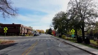 POV, parlak sonbahar ağaçları ile banliyö caddesi boyunca hareket eden arabadan ateş ediyor. Sıcak sonbahar renkleri ve parlak mavi gökyüzü mahallelerin güzel bir resmini oluşturur. - Evet. Yüksek kalite 4k görüntü