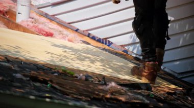 Roofer konutun üzerine ahşap bir panel yerleştiriyor. Çatı yenileme elementi. Yüksek kalite 4k görüntü