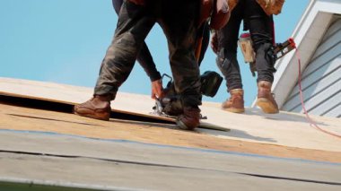 Roofer konutun ahşap panellerini kesiyor. Çatı yenileme elementi. Yüksek kalite 4k görüntü