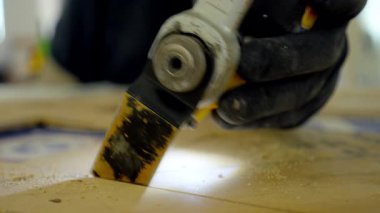 Elektrikli testere, elektrik marangozu çoklu salınımlı alet. Adam inşaat alanındaki kontrplağı kesiyor. Yüksek kalite 4k görüntü