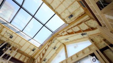 Evin çatısındaki ahşap duvarların arasına ya da inşaat alanına fiberglas yalıtım malzemesi yerleştirilmiş. Manzarayı kapat. Yüksek kalite 4k görüntü