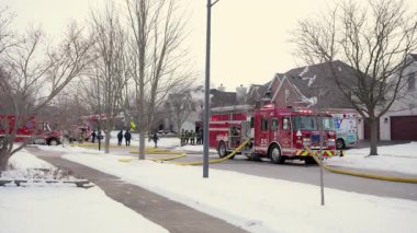 Bir sürü itfaiyeci ve yanan ışıkları olan acil durum araçları şehrin caddesine park etmiş. Dikiz aynası. Naperville lL ABD. 02 Şubat 2025. Yüksek kalite 4k görüntü