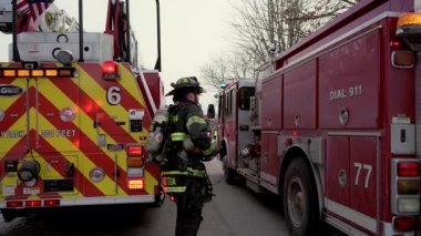 İtfaiyeci şehir caddesinde acil durum araçları arasında yürüyor. Dikiz aynası. Naperville lL ABD. 02 Şubat 2025. Yüksek kalite 4k görüntü