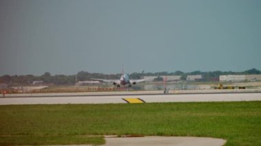 Uçak güneşli bir günde havaalanının pistine iniyor. Yavaş çekim. Yüksek kalite 4k görüntü