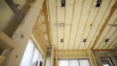 Fiberglas yalıtımı tavandaki ahşap duvar çivileri ya da inşaat alanı arasına kurulmuş. Manzarayı kapat. Yüksek kalite 4k görüntü