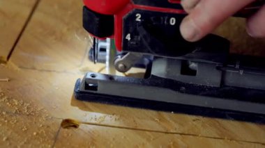 Yapboz elektrikli alet kullanan kişi. İşçi iki eliyle yapboz tutuyor ve tahtadaki işaretli çizgiler boyunca ona rehberlik ediyor. - Evet. Yüksek kalite 4k görüntü