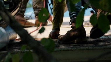 Roofer yeni bir çatı kaplaması kuruyor, üzerinde yapışkan yüzeyi var. Kendi kendine yapışan çatı sistemi süreci. Yüksek kalite 4k görüntü