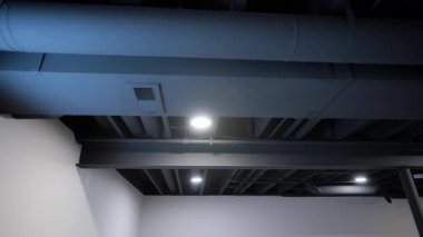 Elektrik ve Hvac hava sistemleri modern binanın tavanındaki kutuplar ve metal borularla iletişim kuruyor. Stabil atış. Yüksek kalite 4k görüntü