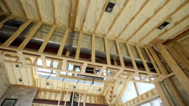 Fiberglas yalıtımı evin tavanındaki ahşap duvar çivileri arasına kurulmuş. Manzarayı kapat. Yüksek kalite 4k görüntü