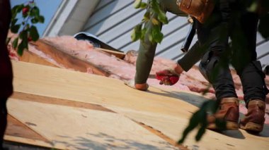 Çatıcılar konut evinin üzerine ahşap paneller diziyorlar. Çatı yenileme elementi. Yüksek kalite 4k görüntü