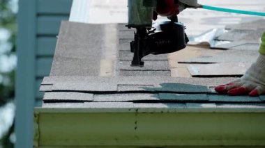 Çatıcılar bir eve yeni bir çatı kiremidi çakıyor. Çatı yenileme elementi. Yüksek kalite 4k görüntü
