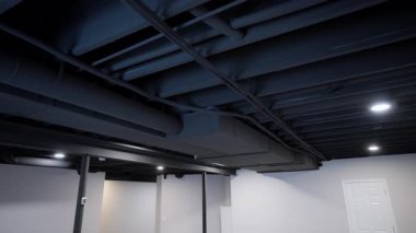 Elektrik ve Hvac hava sistemleri modern binanın tavanındaki kutuplar ve metal borularla iletişim kuruyor. Stabil atış. Yüksek kalite 4k görüntü