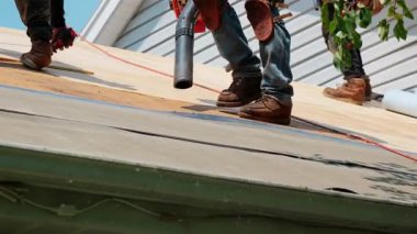 Roofer, yerleşim yerindeki ahşap panellerden toz üflüyor. Çatı yenileme elementi. Yüksek kalite 4k görüntü
