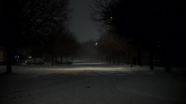Kar fırtınası gecesi karla kaplı, donmuş bir caddenin stabil görüntüsü. Yüksek kalite 4k görüntü