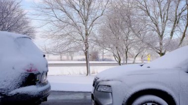 Güneşli bir kış gününde yoğun otoyolun arka planında kar arabaları kapladı. Bir yerleşim bölgesinde kış günleri. Yüksek kalite 4k görüntü