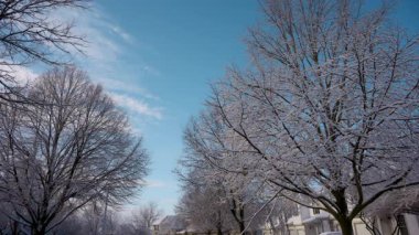 Kar güneşli bir kış gününde banliyö caddesini ulaşımla kapladı. Bir yerleşim bölgesinde kış günleri ve mavi gökyüzü. Yüksek kalite 4k görüntü