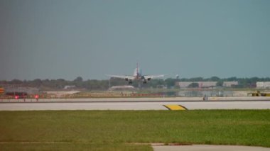Uçak güneşli bir günde havaalanının pistine iniyor. Yavaş çekim görüntüleri. Yüksek kalite 4k görüntü