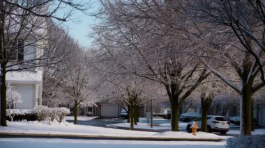 Güneşli bir kış gününde ulaşımı olan karlı banliyö sokakları. Bir yerleşim bölgesinde kış günleri. Yüksek kalite 4k görüntü