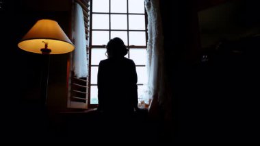 Gelin, düğün günü pencerenin önünde dikiliyor ve bakıyor. - Evet. Yüksek kalite 4k görüntü