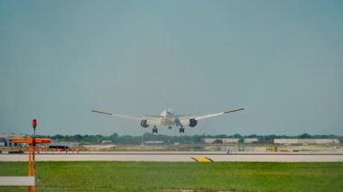 Güneşli bir günde dikenli tellerle havaalanına inen uçak. Yavaş çekim zoom görüntüsü. Yüksek kalite 4k görüntü