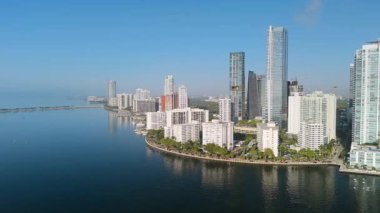 Gün doğumunda Miami şehir merkezinin ufuk çizgisi ve körfez manzarası. Sakin sular ve sabah ışığı modern gökdelenleri aydınlatıyor. Yüksek kalite 4k görüntü