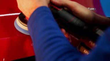 Erkek işçi araba tamirhanesinde araba kaportasını cilalamaya başlar. Yüksek kalite 4k görüntü