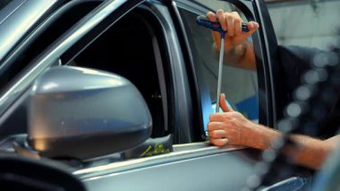 Araba tamirhanesinde tamirci, araba gövdesindeki göçükleri tamir etmek için aletler. PDR. Kapatın. Yüksek kalite 4k görüntü