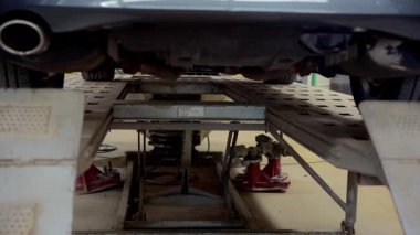 Araba tamirhanesinde asansörde araba kaldırma görüntüsünü kapat. Yüksek kalite 4k görüntü