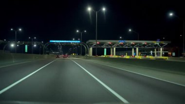 Otobanda çekilen görüntüler, gece boyunca paralı geçiş sistemiyle birlikte boş bir yolda sürüş. Arabalar, kamyonlar yolda. Chicago, IL 'den. 22 Ağustos 2024. Yüksek kalite 4k görüntü