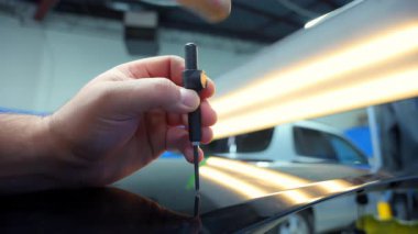 Araba gövdesinde gereksiz çukur onarımının yakın çekim görüntüsü, araba tamircisinde araba gövdesindeki göçükleri onaracak aletlerle tamirci. PDR. Yüksek kalite 4k görüntü