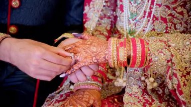 Damat geleneksel kınalı gelin eli için ENGAGEMENT yüzüğünü takıyor. Kırmızı renk geleneksel Hint kıyafetleridir, Hint düğününün unsurları. - Evet. Yüksek kalite 4k görüntü