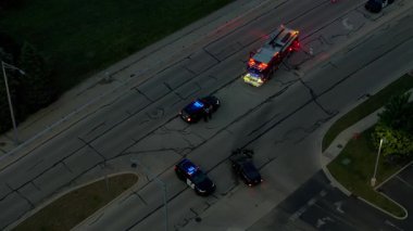 Polis Arabaları ve Çekici Operasyonuyla Gece Yolundaki Kazanın İHA görüntüsü. Yüksek kalite 4k görüntü