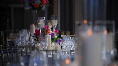 Restorandaki kutlama partisinde servis edilen bardaklar, tabaklar ve mumlarla yakın çekim sahnesi. Düğün, doğum günü, parti. Kamera ağır çekimde hareket ediyor. Yüksek kalite 4k görüntü