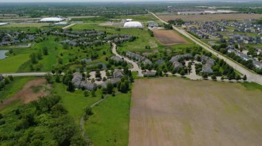 Countryside Fields 'ın geniş hava görüntüsü ve banliyödeki çiftliğin yanında. Yüksek kalite 4k görüntü