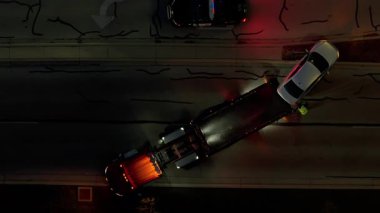 Polis Arabaları ve Çekici Operasyonuyla Gece Yolundaki Kazanın İHA görüntüsü. Üst atış. Yüksek kalite 4k görüntü
