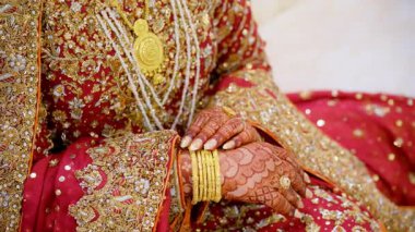 Gelin ellerini geleneksel bir şekilde tutuyor, kırmızı Hint kıyafetleri giyiyor, Hindu düğünü unsurları. - Evet. Yüksek kalite 4k görüntü