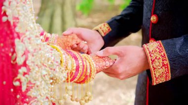 Elini tutan bir çift. Geleneksel kınalı gelin eli. Kırmızı renk geleneksel Hint kıyafetleridir, Hint düğününün unsurları. - Evet. Yüksek kalite 4k görüntü