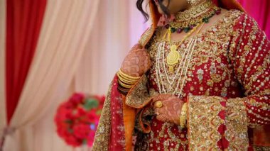 Gelin ellerini geleneksel bir şekilde fotoğraf için poz veriyor, kırmızı geleneksel Hint kıyafetleri giyiyor, Hindu düğününün unsurları. - Evet. Yüksek kalite 4k görüntü