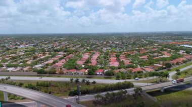 Miami 'nin yerleşim bölgesi yakınlarındaki otoyol kavşağında hızlı hareket eden araçlar FL' de bulutlu bir havada ABD ulaşım altyapısını gösteriyor. Manzarayı kapat. Yüksek kalite 4k görüntü