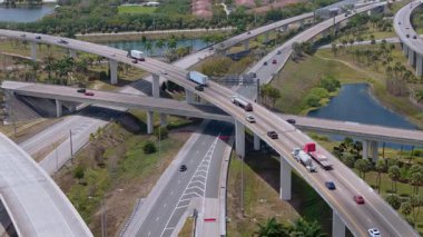 Miami 'de hızlı hareket eden araçlarla otoyol kavşağı, Amerikan ulaşım altyapısını FL' de açık bulutlu bir gökyüzünün altında gösteriyor. Manzarayı kapat. Yüksek kalite 4k görüntü