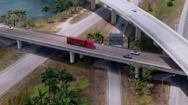 Miami 'de hızlı hareket eden araçlarla otoyol kavşağı, parlak bulutlu bir gökyüzü altında ABD ulaşım altyapısını gösteriyor. Yakın görüş. Yüksek kalite 4k görüntü