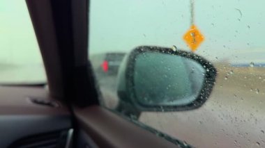 Şiddetli rüzgarla yağmurlu havada otoyolda araba sürmek. Ön yolcu tarafından yan görüş. Yüksek kalite 4k görüntü